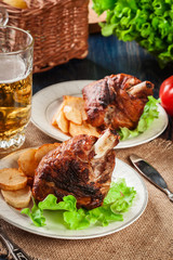 Roasted turkey knuckle with fried potato slices