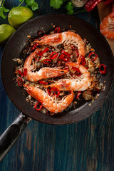 Shrimps roasted on frying pan with onion, garlic and chili