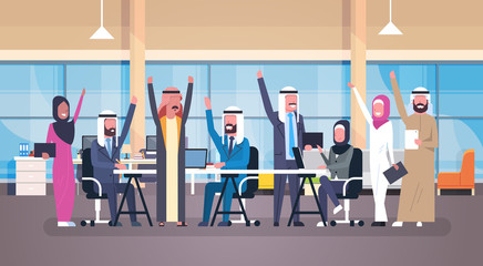 Group Of Cheerful Arabic Business People Happy Hold Raised Hands Sitting Together At Office Desk Muslim Workers Team Success Flat Vector Illustration