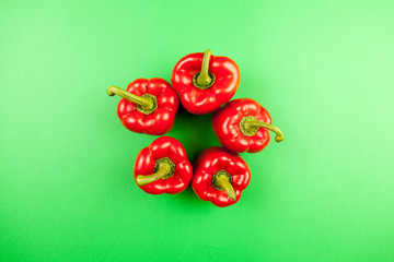Top view on fresh sweet red pepper on green background