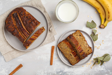 Sliced banana bread with cinnamon in gray plates. Gray background. Vegan Healthy Food Concept. Top view.