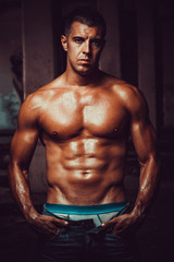 Fototapeta na wymiar Athletic young bodybuilder shows muscles after a workout. Concept handsome sport man.