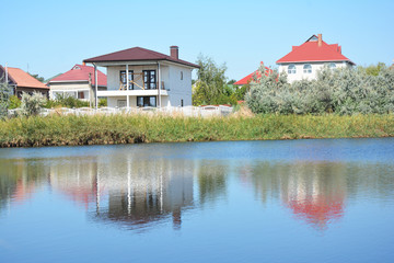 Building house construction with metal roof on the river bank with beautiful view.