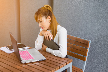 Asian woman using tablet and laptop