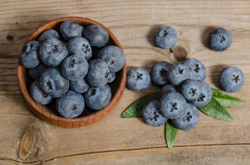blueberries in wooden bowl  and on wooden background