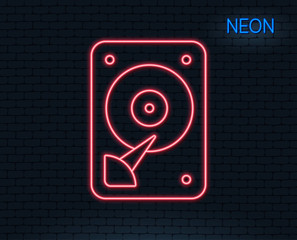 Neon light. HDD icon. Hard disk storage sign. Hard drive memory symbol. Glowing graphic design. Brick wall. Vector