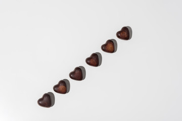 top view of delicious chocolate heart shaped candies isolated on grey