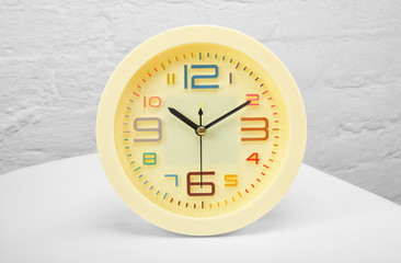 Yellow alarm clock on a white table