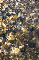 sea pebble beach with multicoloured stones, waves with foam
