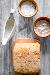 Make bread. Loaf and ingredients on light woden table background