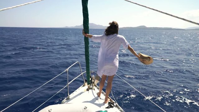 Woman enjoying, relaxing while sailing boat on sea
