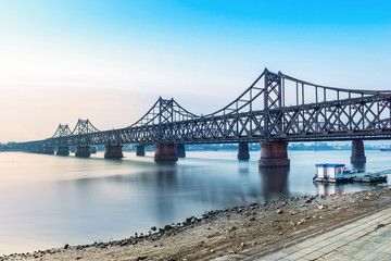 Yalu River Bridge and Yalu River Scenic Areas at morning. In the distance is North Korea. Located in Dandong, Liaoning, China.