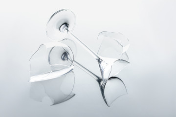 broken wineglass on white reflecting surface