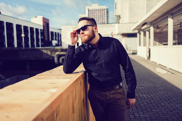 Young handsome man in stylish black clothes and sunglasses.