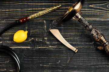 Dismantled parts of hookah on a wooden background with lemon fru