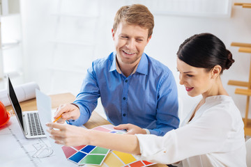 Sharing ideas. Positive enthusiastic smart designers sitting together at their working place and...