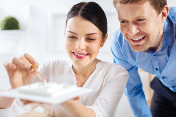 Delighted coworkers. Positive young skilled engineers being in a cheerful working mood while...