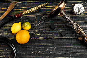 Dismantled parts of hookah on a wooden background with lime frui