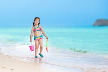 Fototapeta na wymiar Kids play on tropical beach. Sand and water toy.