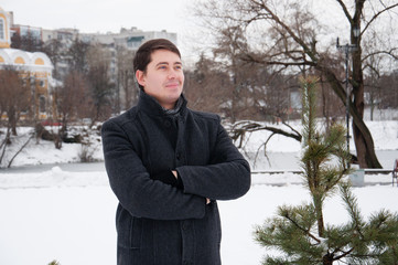 Young man, businessman walking in winter park