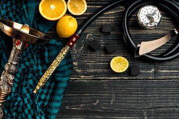 Top view of Hookah with orange fruit on a wooden background