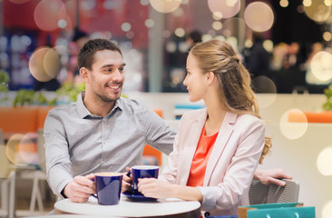 happy couple with shopping bags drinking coffee