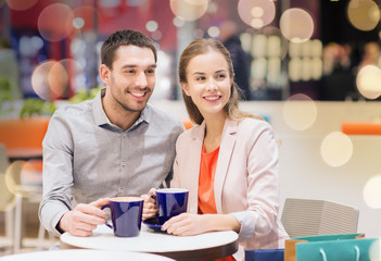 happy couple with shopping bags drinking coffee