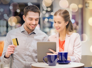 couple with tablet pc and credit card in mall