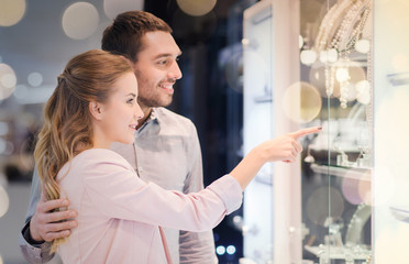 couple looking to shopping window at jewelry store