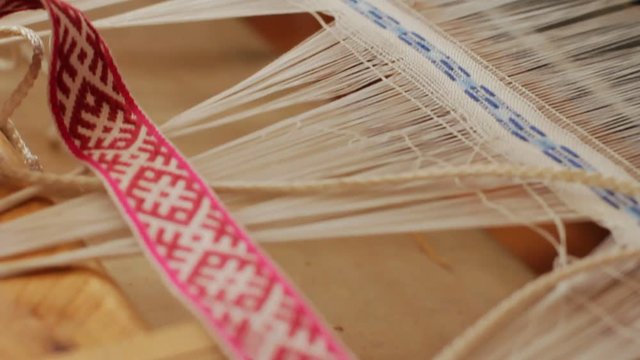 Weaving machine in action. Closeup of automate process of fabric production. Weaving tool producing material. Textile industry concept. Weaving loom manufacturing linen yarn pattern