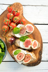 fresh ripe sliced fig on toast bread mozzarella cheese Italian crostini dish light lunch starter