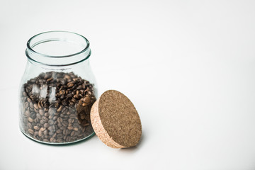 glass bottle with coffee beans and cork isolated on white