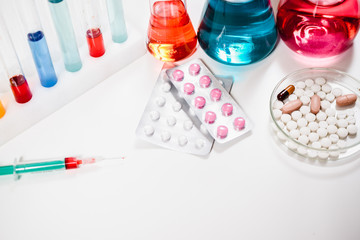 pills and syringe. injection and vaccination. drug discovery, pharmacology and biotechnology concept. science and medical research background with copy space.