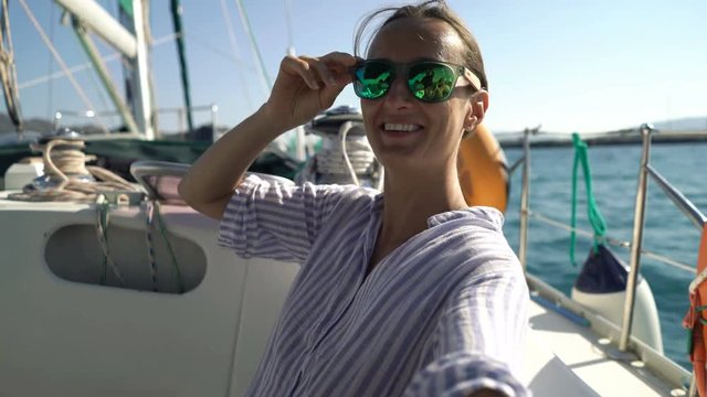 Happy woman taking selfie photos while sailing boat on ocean
