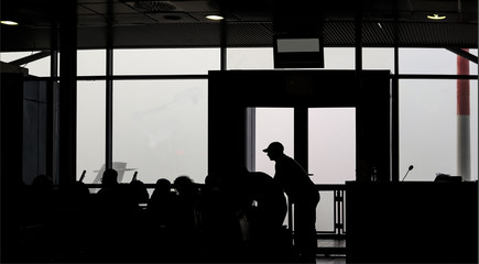 Airport in 0 percent visibility -  silhouettes of fogged in passengers waiting to fly out