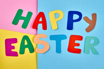 Happy Easter colorful letters. Inscription Happy Easter cut from colorful paper on bright paper background, top view. Easter festive mood.