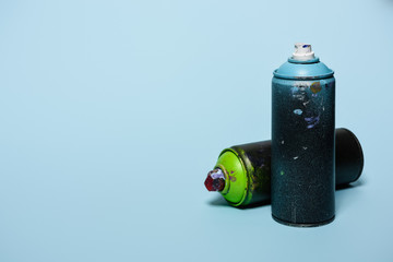 close up view of arranged cans with aerosol paint isolated on blue