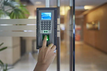 Man or woman push finger down on  electronic control machine to access security door system - obrazy, fototapety, plakaty