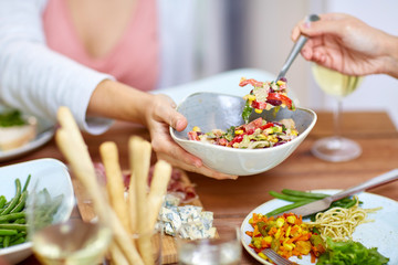 people eating salad at table with food