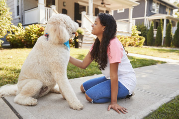 Girl Walking Dog Along Suburban Street