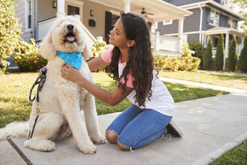 Girl Walking Dog Along Suburban Street