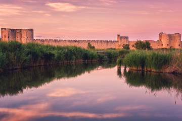 Scenic sunset view of the ancient city wall of the Aigues-Mortes, famous medieval fortress in South...