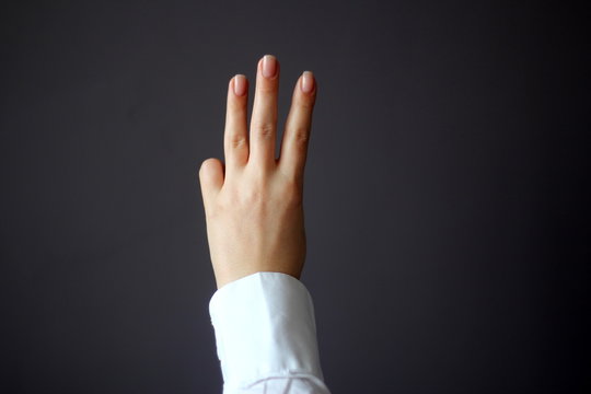 Young Woman's Hand Shows Three Fingers or Shows Direction Gesture