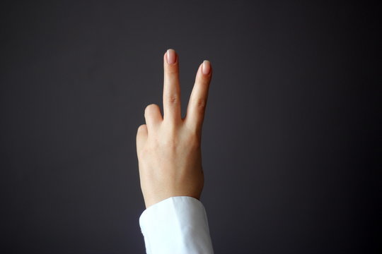 Young Woman's Hand Shows V Sign Gesture