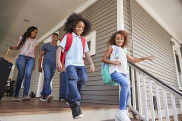 Family With Luggage Leaving House For Vacation