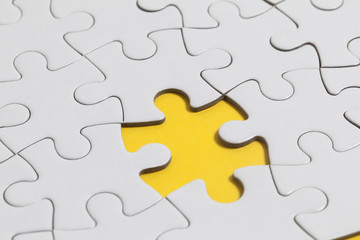 White jigsaw puzzle pieces on a yellow background. Business solution concept