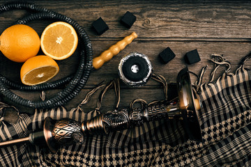Dismantled parts of hookah on a wooden background with orange fr