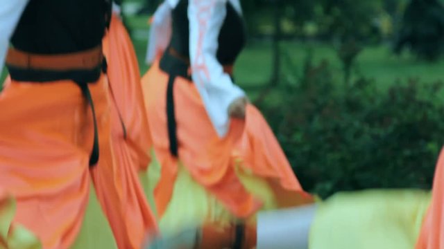 Folklore dance outdoors. Closeup of group of people dancing Irish national dance. Folk dancers background. National entertainment in traditional dress