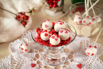 White chocolate sweets and cake pops decorated with little confectionery hearts
