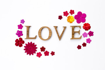 Wooden love text with colorful paper flower frame on white texture background, Valentine card concept background